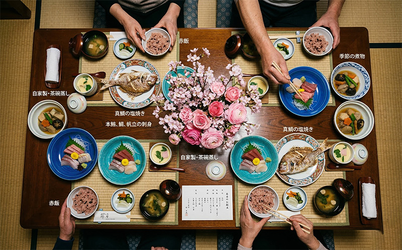 百寿祝いの懐石料理を真上から撮影したピンクの花と鯛の姿焼き