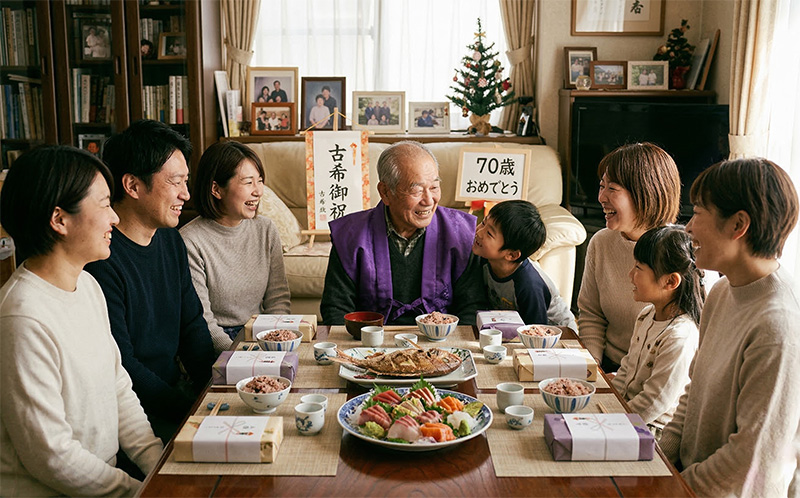 自宅で紫のちゃんちゃんこを着た70歳男性と家族6人の古希祝い食事会