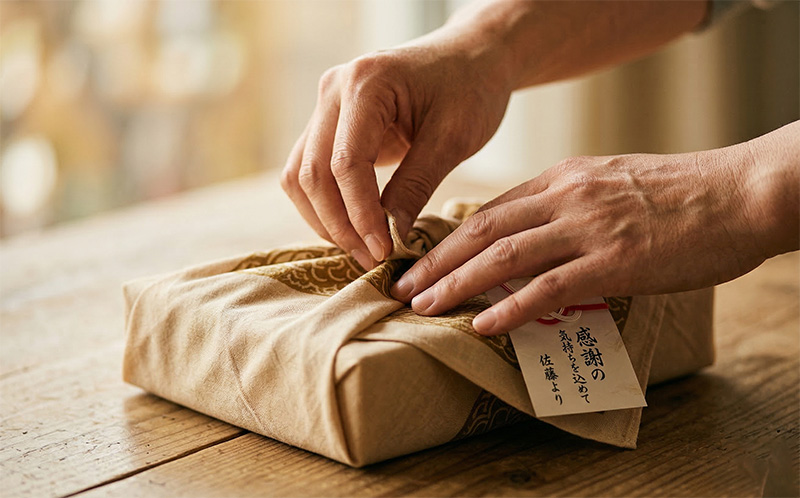 ベージュの和柄風呂敷でギフトを丁寧に包む手元