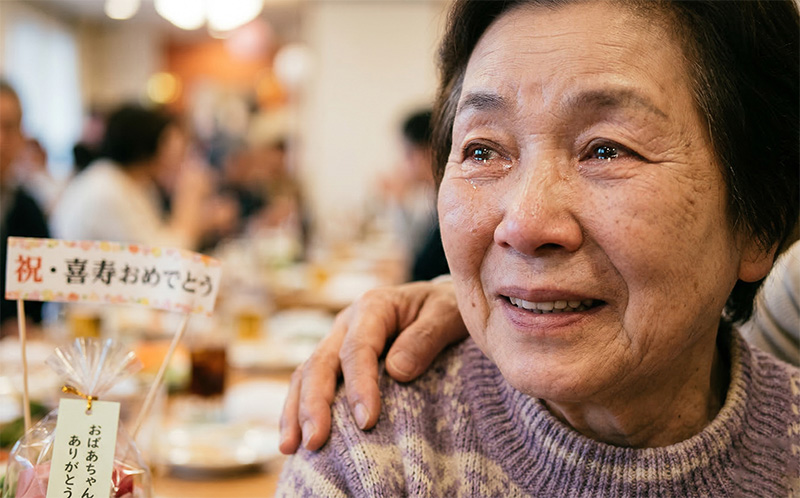 お祝いの席で感動の涙を浮かべる高齢女性のポートレート