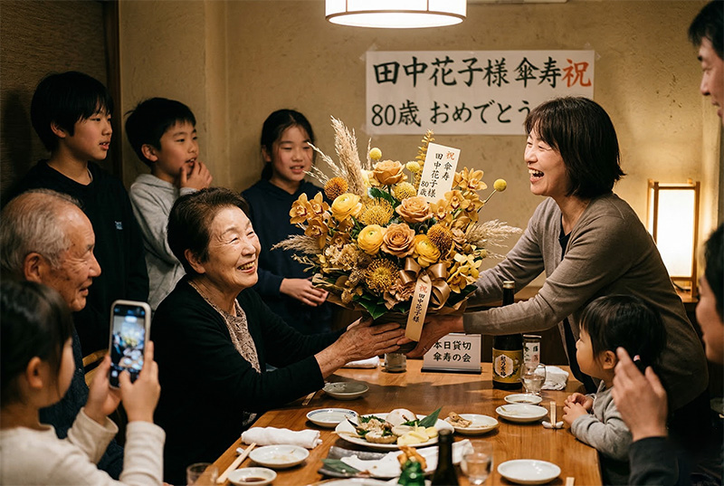 傘寿祝いで家族からゴールドの花束を受け取り笑顔の80歳女性