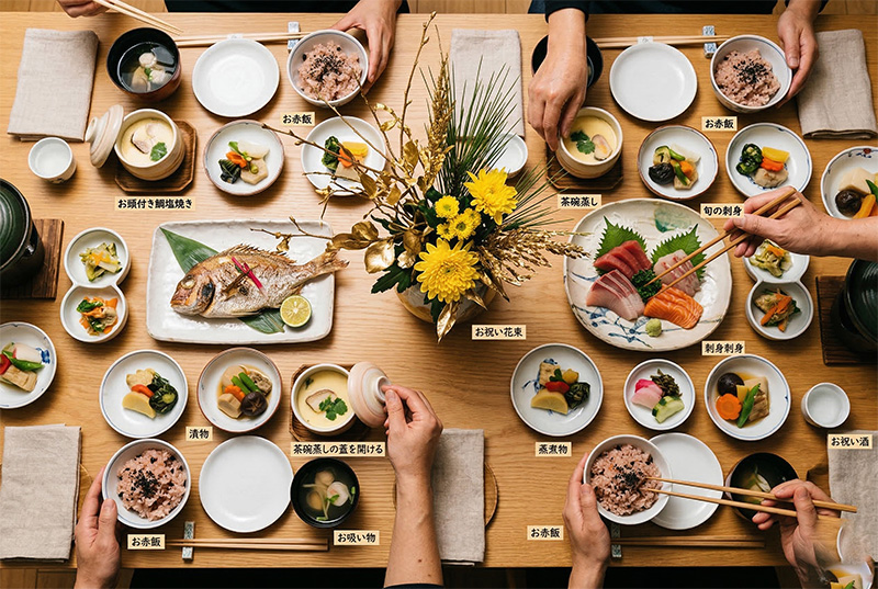 米寿祝いの懐石料理を真上から撮影した鯛の姿焼きと黄色い花