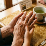 祖父と孫の手を優しく握り合うクローズアップ